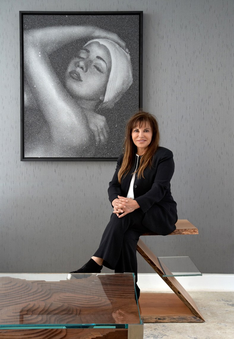 Carole Feuerman in front of a print by her entitled "Shower [full face]".